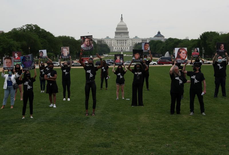 &copy; Reuters. FILE PHOTO: Survivors and family and friends of victims of gun violence hold up photographs of people lost to gun violence after delivering a "State of the Union on the Gun Violence Crisis in America" on the National Mall in Washington, U.S. April 29, 202
