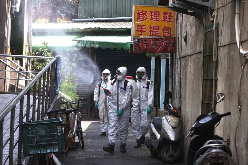 © Reuters. Soldiers in protective suits disinfect a street following the recent surge of coronavirus disease (COVID-19) infections, in Tucheng district of New Taipei City, Taiwan May 27, 2021. REUTERS/Ann Wang