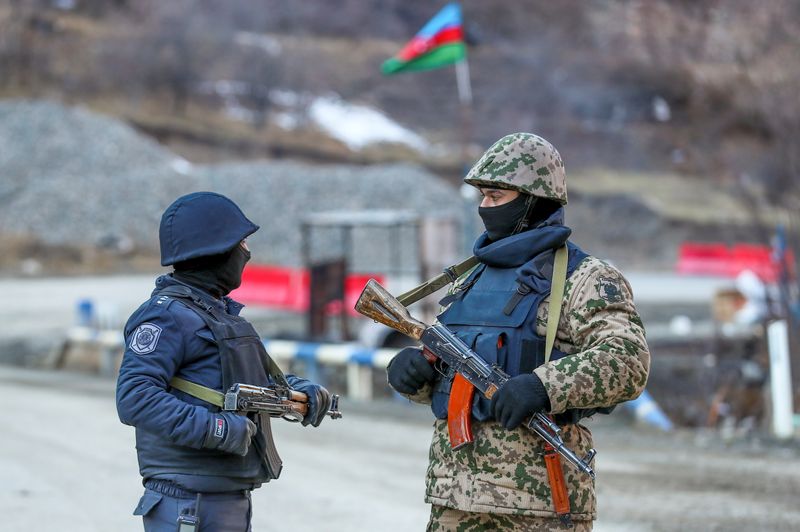 &copy; Reuters. An Azeri soldier and police officer talk as they stand guard at the Kalbajar district, Azerbaijan, December 21, 2020. Picture taken December 21, 2020.  REUTERS/Aziz Karimov