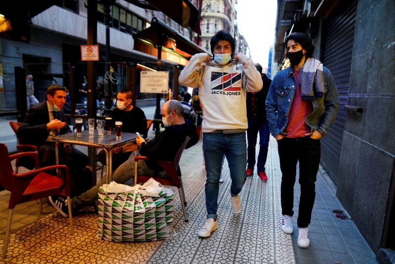 &copy; Reuters. FOTO DE ARCHIVO: Personas con mascarilla pasan junto a los clientes de un bar después de que los bares reabrieran en el País Vasco español, en medio del brote de la enfermedad del coronavirus (COVID-19), en Bilbao, España, 19 de febrero de 2021. REUTE