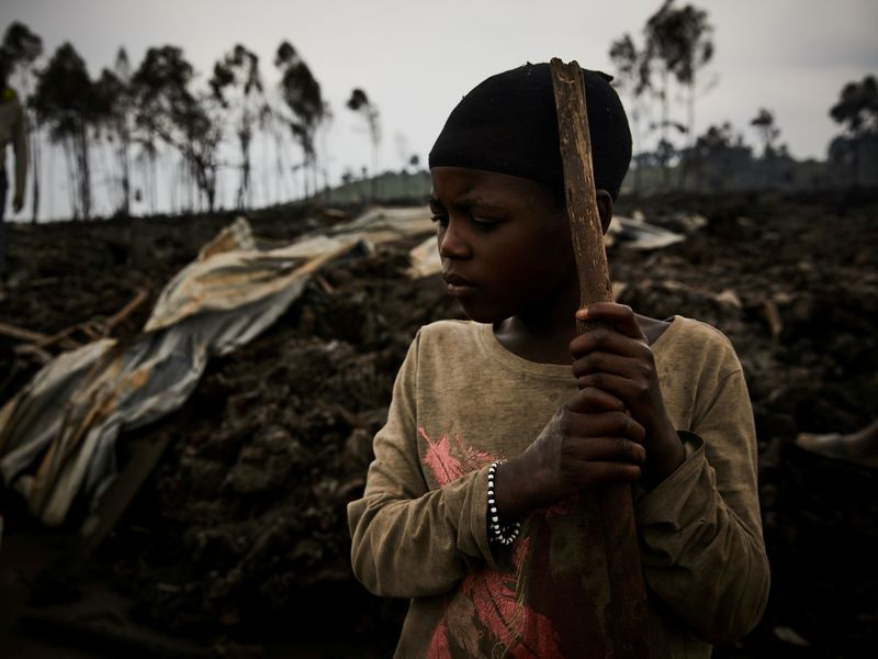 &copy; Reuters. A Congolese child, Jolie, 11, prepares to evacuate from recurrent earth tremors as aftershocks after homes were covered with lava deposited by the eruption of Mount Nyiragongo near Goma, in the Democratic Republic of Congo May 25, 2021. Hugh Kinsella Cunn