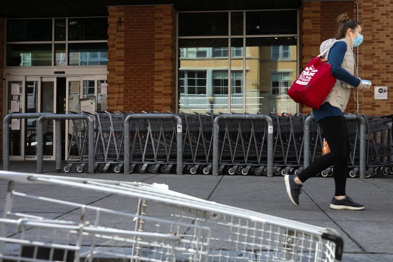 &copy; Reuters. FILE PHOTO: A shopper walks past a row of shopping carts outside of a Whole Foods following reports that multiple employees tested positive for the coronavirus disease (COVID-19) at the Logan Circle Whole Foods Market grocery store, in Washington, U.S., A