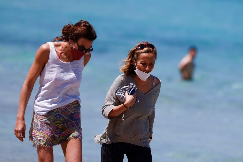 &copy; Reuters. Due donne indossano la mascherina sulla spiaggia di Mondello. Palermo, Italia, 21 maggio 2021. REUTERS/Guglielmo Mangiapane