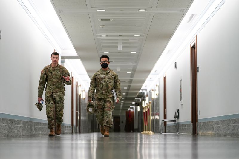 © Reuters. FILE PHOTO: Members of the National Guard walk in the Dirksen Senate Office Building on Capitol Hill on the final days of their deployment following the January 6 Capitol riots in Washington, U.S., May 23, 2021. REUTERS/Sarah Silbiger
