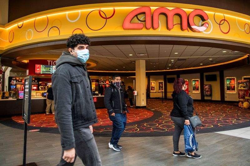 © Reuters. FILE PHOTO: People wear face masks as they walk by a movie theater during the coronavirus disease (COVID-19) pandemic in Newport, New Jersey, U.S., April 2, 2021. REUTERS/Eduardo Munoz/File Photo