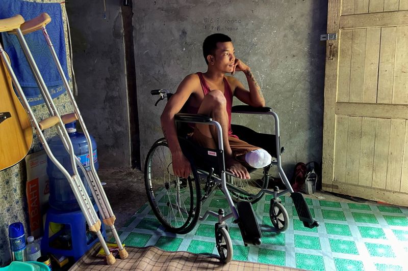 &copy; Reuters. Ko Phyo, 24, a protester who lost one leg during an anti-coup protest, sits in his wheelchair at his home on the outskirts of Yangon, Myanmar, April 24, 2021. The bullet that hit Ko Phyo severed three arteries. The soldier who fired the shot removed it wi