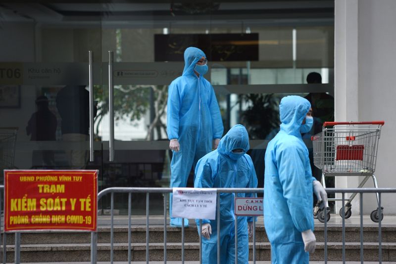 &copy; Reuters. FILE PHOTO: Medical workers in protective suits stand outside a quarantined building amid the coronavirus disease (COVID-19) outbreak in Hanoi, Vietnam, January 29, 2021. REUTERS/Thanh Hue