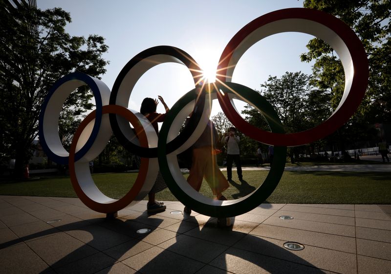 &copy; Reuters. Visitors try to take photos in front of the Olympic Rings monument outside the Japan Olympic Committee (JOC) headquarters near the National Stadium, the main stadium for the 2020 Tokyo Olympic Games that have been postponed to 2021 due to the coronavirus 