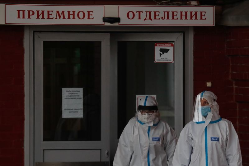 &copy; Reuters. Medical specialists wearing protective gear walk outside a hospital, amid the outbreak of the coronavirus disease (COVID-19) in Saint Petersburg, Russia November 11, 2020. The sign reads: "Admission department". REUTERS/Anton Vaganov