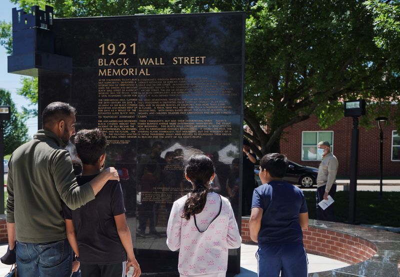 &copy; Reuters. FILE PHOTO: A family reads the Black Wall Street Memorial during festivities of the 100 year anniversary of the 1921 Tulsa Massacre in Tulsa, Oklahoma, U.S., May 29, 2021. REUTERS/Lawrence Bryant