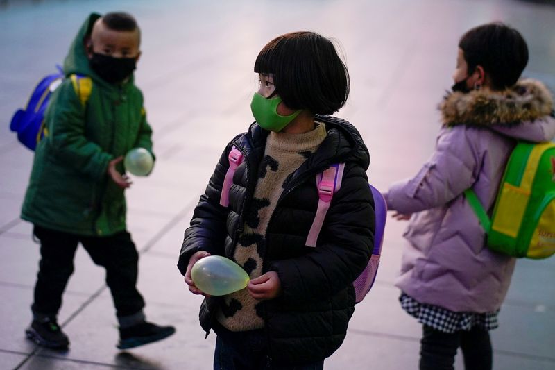 &copy; Reuters. Dei bambini indossano la mascherina alla stazione ferroviaria di Shanghai, Cina, 5 marzo 2020 REUTERS/Aly Song