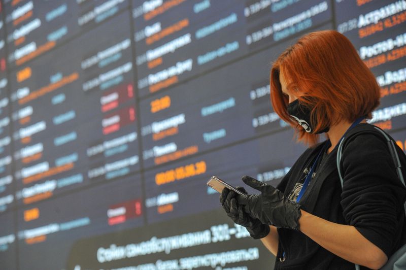 &copy; Reuters. A woman wearing a protective face mask and gloves stands in front of a flight information board at Sheremetyevo International Airport amid the outbreak of the coronavirus disease (COVID-19) outside Moscow, Russia June 4, 2020. Alexander Avilov/Moscow News