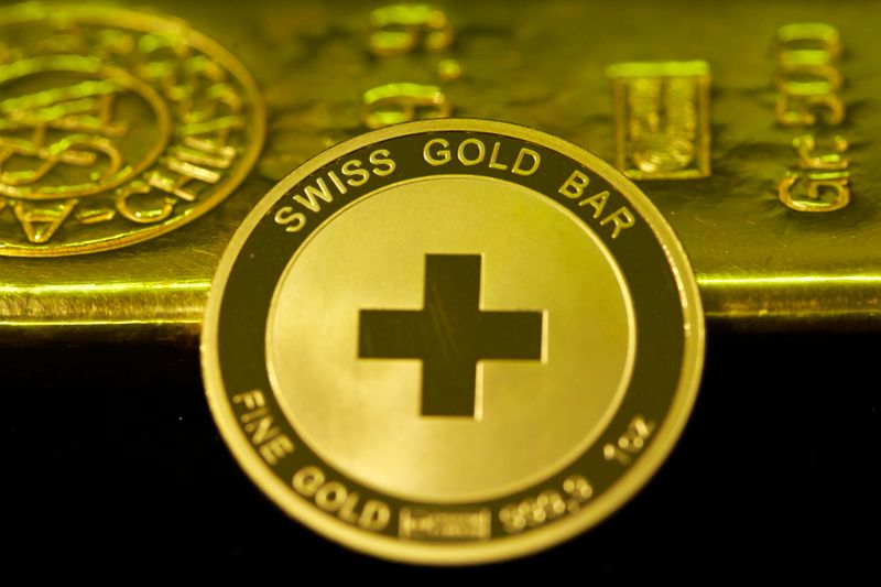 &copy; Reuters. An ounce of gold coin is pictured in front of a 500g ingot at Jolliet numismatic shop in Geneva November 19, 2014. Support among Swiss voters for a referendum proposal that would force a huge increase in the central bank's gold reserves has slipped to 38 