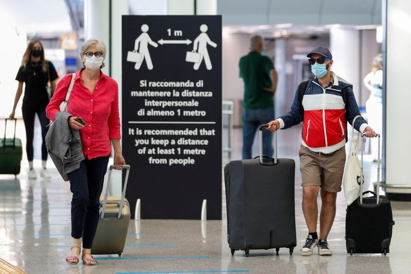 &copy; Reuters. FILE PHOTO: Passengers wearing protective face masks walk at Fiumicino Airport on the day EU governments agreed a "safe list" of 14 countries for which they will allow non-essential travel starting from July, following the coronavirus disease (COVID-19) o