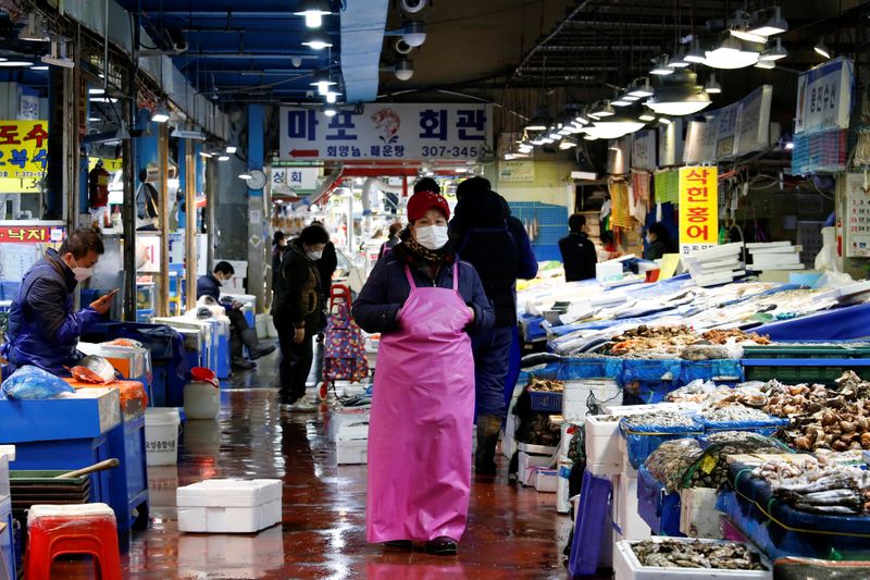 &copy; Reuters. FILE PHOTO: A shopkeeper wearing a mask to prevent contracting the coronavirus waits for a customer at a traditional market in Seoul, South Korea, February 27, 2020.    REUTERS/Heo Ran