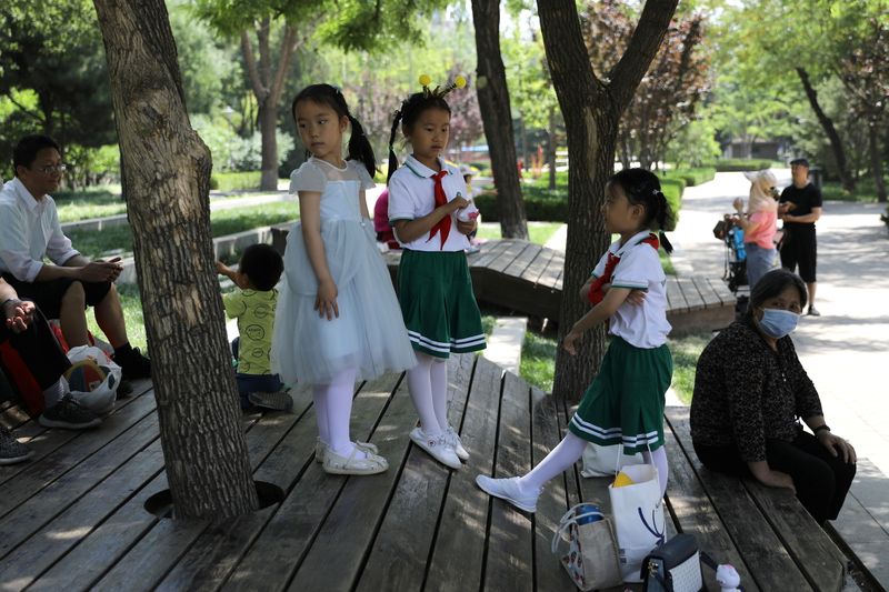 &copy; Reuters. 　中国政府は５月３１日、１組の夫婦に３人まで子どもを持つことを認める方針を発表した。写真は北京で遊ぶ子どもたち。１日撮影（２０２１年　ロイター/Tingshu Wang）