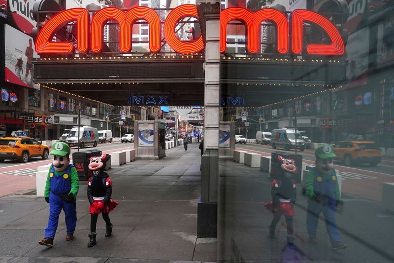 © Reuters. FILE PHOTO: Times Square characters who pose for photos for money walk past an AMC theatre amid the coronavirus disease (COVID-19) pandemic in the Manhattan borough of New York City, New York, U.S., January 27, 2021. REUTERS/Carlo Allegri