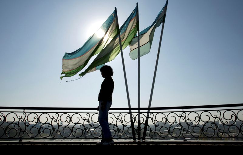 &copy; Reuters. A girl is silhouetted against the sun standing next to Uzbek flags in Tashkent November 5, 2005.    REUTERS/Shamil Zhumatov/File Photo