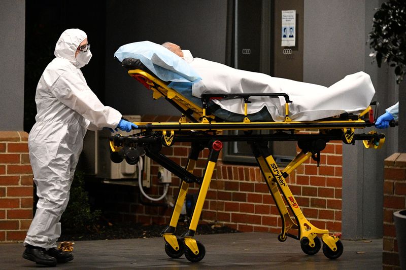 © Reuters. Healthcare workers transport a person into a patient transport vehicle at the Arcare Aged Care facility as a lockdown resulting from an outbreak of the coronavirus disease (COVID-19) continues in Melbourne, Australia, June 2, 2021.  AAP Image/James Ross via REUTERS  ATTENTION EDITORS - THIS IMAGE WAS PROVIDED BY A THIRD PARTY. NO RESALES. NO ARCHIVE. AUSTRALIA OUT. NEW ZEALAND OUT