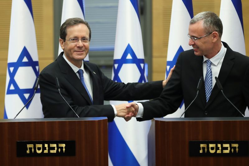 &copy; Reuters. Il caniddato alla presidenza Isaac Herzog stringe la mano a Yariv Levin, speaker dello Knesset, durante una sessione speciale per l'elezione del nuovo presidente. Gerusalemme, 2 giugno 2021 REUTERS/Ronen Zvulun