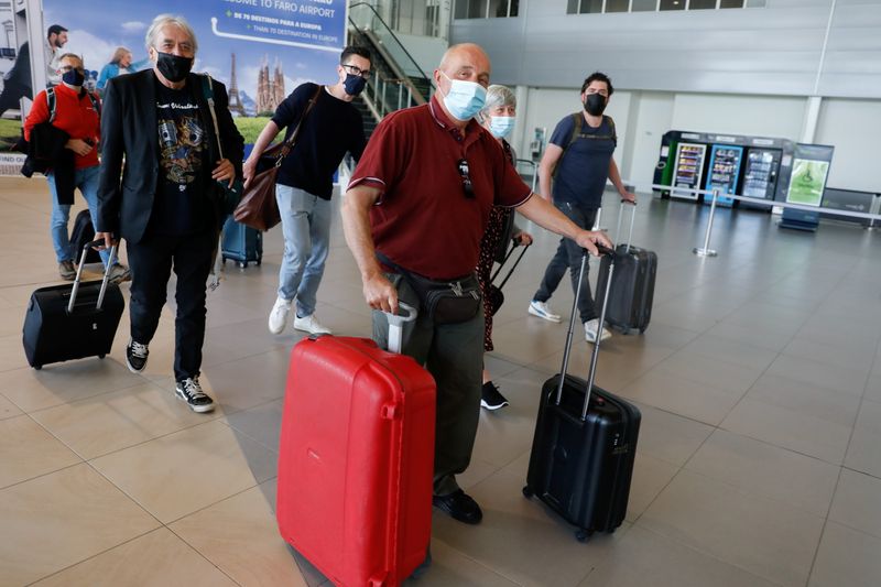 © Reuters. FILE PHOTO: People arrive at Faro Airport from Manchester on the first day that Britons are allowed to enter Portugal without needing to quarantine, as coronavirus disease (COVID-19) restrictions continue to ease, in Faro, Portugal, May 17, 2021. REUTERS/Pedro Nunes/File Photo