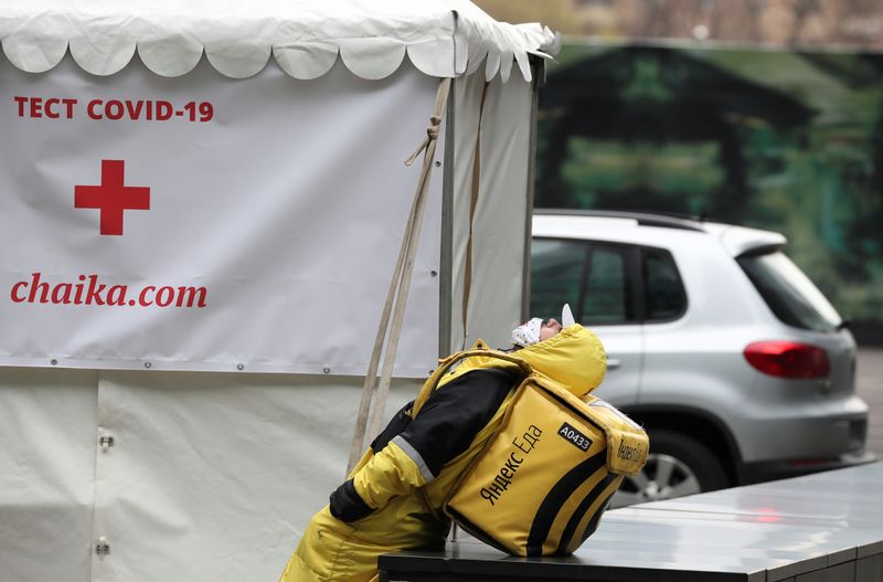 &copy; Reuters. A Yandex.Eats food delivery courier rests near a mobile laboratory, which carries out tests to detect the coronavirus disease (COVID-19) in Moscow, Russia April 27, 2020. REUTERS/Evgenia Novozhenina