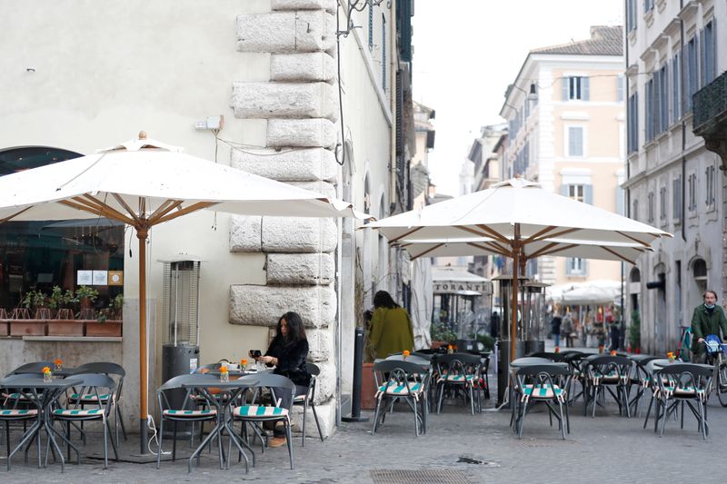 &copy; Reuters. FILE PHOTO: A woman sits at a cafe at Campo de' Fiori after the coronavirus disease (COVID-19) restrictions were eased in Lazio region, Rome, Italy, February 1, 2021. REUTERS/Yara Nardi/File Photo