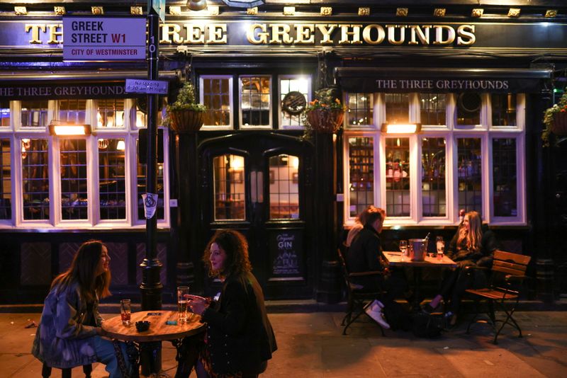 &copy; Reuters. FILE PHOTO: People drink at tables outside a pub in Soho amid the coronavirus disease (COVID-19) outbreak, in London, Britain, April 17, 2021. REUTERS/Tom Nicholson