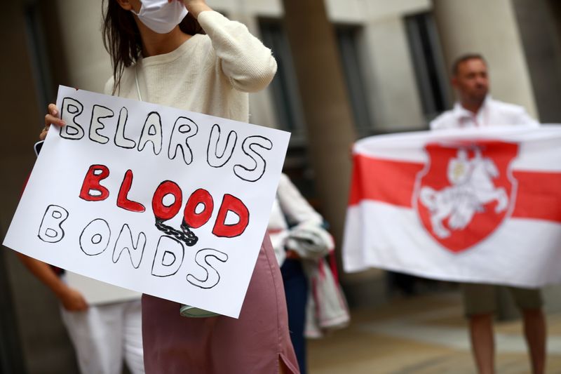 © Reuters. FILE PHOTO: A woman holds a banner during a protest against Belarusian President Alexander Lukashenko's regime in London, Britain September 3, 2020. REUTERS/Hannah McKay/File Photo