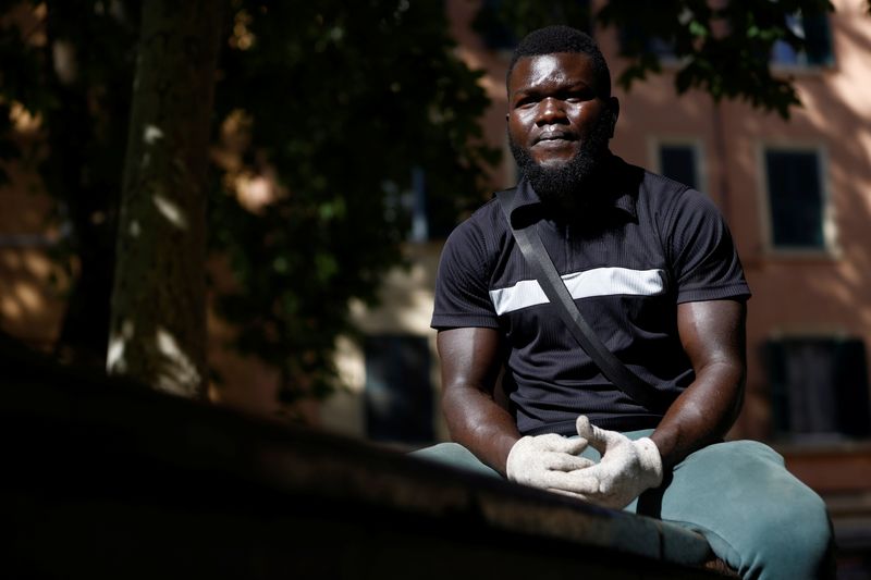 &copy; Reuters. Frank Agbontaen, 30, from Nigeria, poses for a portrait after cleaning a square to make extra money in Rome, Italy, June 3, 2021. REUTERS/Guglielmo Mangiapane
