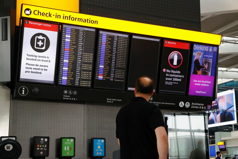 &copy; Reuters. FILE PHOTO: A man looks at a check-in information board in the departures area of Terminal 5 at Heathrow Airport in London, Britain, May 17, 2021. REUTERS/John Sibley
