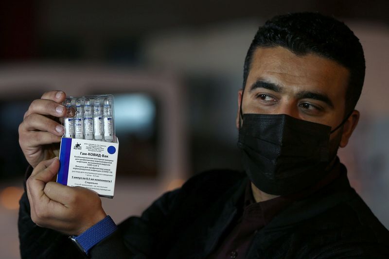 &copy; Reuters. A Palestinian man displays Russia's Sputnik V vaccines, sent by United Arab Emirates, amid the coronavirus disease (COVID-19) outbreak, at Rafah crossing in the southern Gaza Strip March 11, 2021. REUTERS/Ibraheem Abu Mustafa