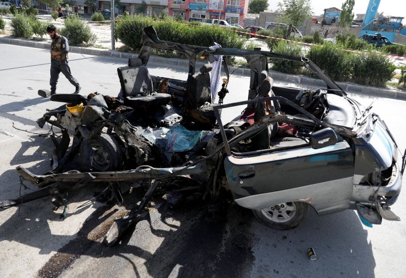&copy; Reuters. أفراد من الشرطة الأفغانية يفحصون شاحنة مدمرة عقب انفجار في كابول يوم الخميس. صورة لرويترز.
