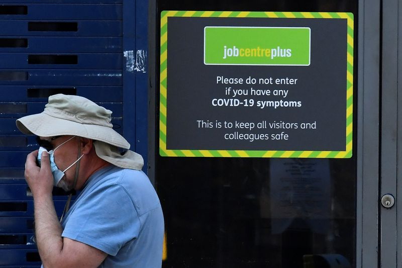 &copy; Reuters. FILE PHOTO: A person wearing a protective face mask walks past a Job Centre Plus office, amidst the outbreak of the coronavirus disease (COVID-19) in London, Britain, August 11, 2020. REUTERS/Toby Melville