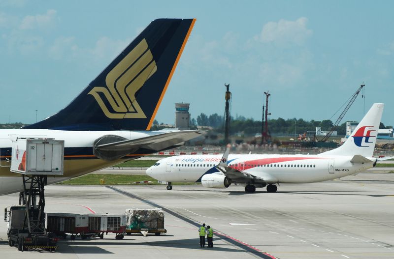 &copy; Reuters. FOTO DE ARCHIVO: Aviones de las aerolíneas Malaysia Airlines y Singapore Airlines en el aeropuerto Changi de Singapur, el 5 de julio de 2019. REUTERS/Lim Huey Teng