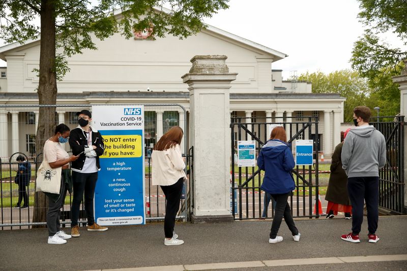 &copy; Reuters. FILE PHOTO: People wait in line in front of De Montfort Hall to receive the coronavirus disease (COVID-19) vaccine, in Leicester, Britain May 27, 2021. REUTERS/Andrew Boyers