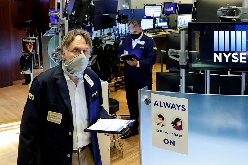 © Reuters. FILE PHOTO: Traders wearing masks work, on the first day of in person trading since the closure during the outbreak of the coronavirus disease (COVID-19) on the floor at the New York Stock Exchange (NYSE) in New York, U.S., May 26, 2020. REUTERS/Brendan McDermid