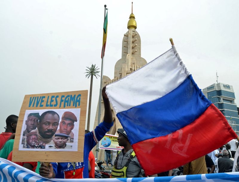 &copy; Reuters. Malians holds a photograph with an image of coup leader Colonel Assimi Goita, who overthrew the president and prime minister this week, and Russia's flag during a pro-Malian Armed Forces (FAMA)  demonstration in Bamako, Mali, May 28, 2021. REUTERS/ Amadou