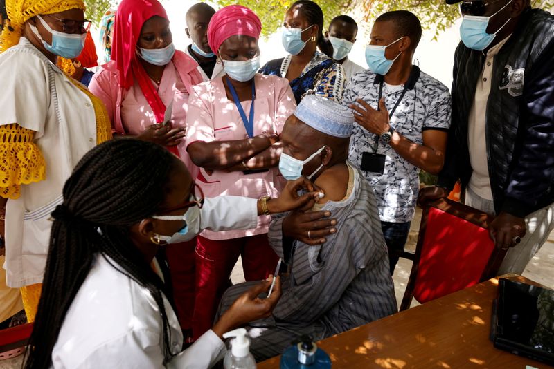 &copy; Reuters. FILE PHOTO: A health worker receives a dose of coronavirus disease (COVID-19) vaccine in Dakar, Senegal February 24, 2021. REUTERS/ Zohra Bensemra