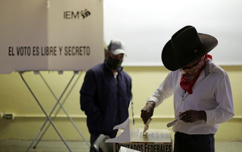 © Reuters. A man casts his vote at a polling station during mid-terms elections in Morelia, Mexico June 6, 2021. REUTERS/Alan Ortega 