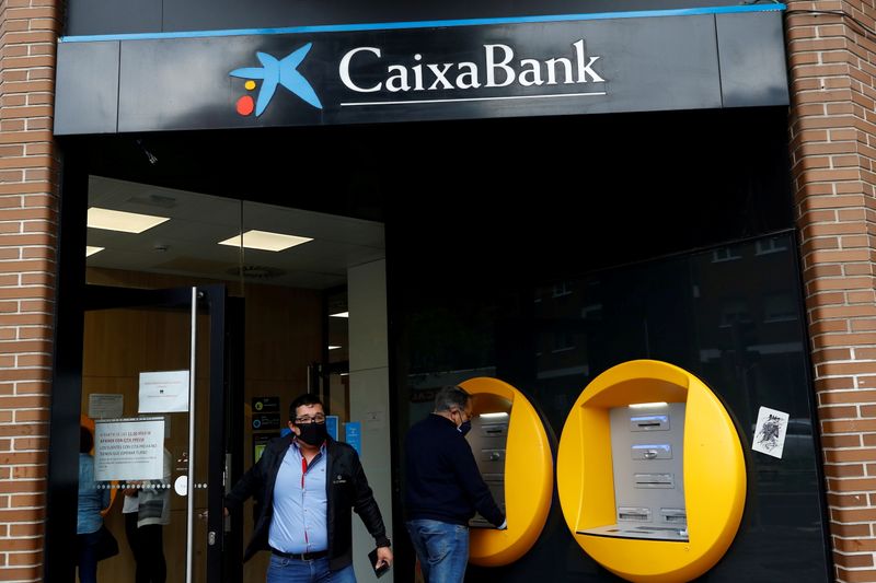 &copy; Reuters. FILE PHOTO: A person walks out of a Caixabank's bank branch in Madrid, Spain, April 20, 2021. REUTERS/Susana Vera/File Photo