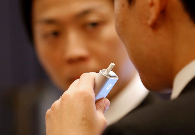© Reuters. FILE PHOTO: Attendees try British American Tobacco's new tobacco heating system device 'glo' after a news conference in Tokyo, Japan, November 8, 2016. REUTERS/Kim Kyung-Hoon/File Photo