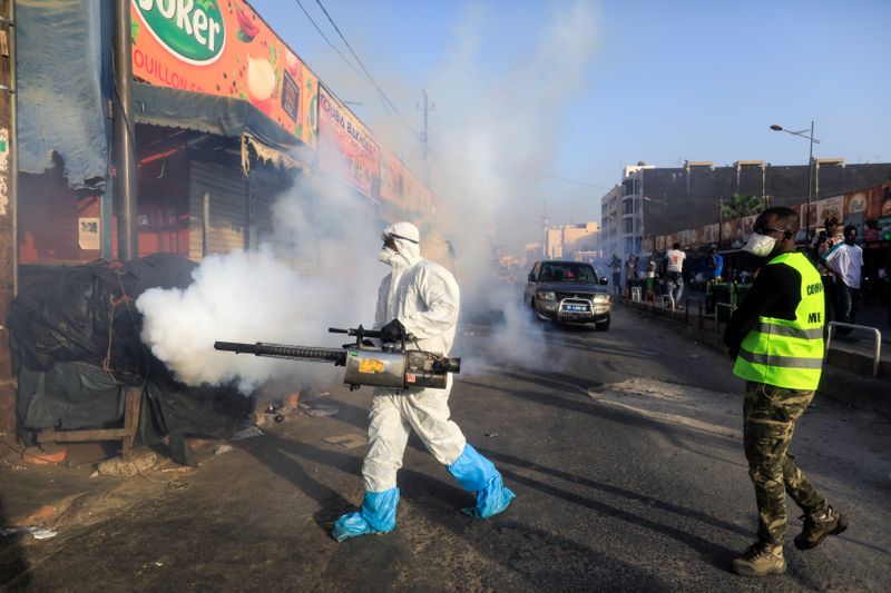 &copy; Reuters. FILE PHOTO: A member of local hygiene services wears a protective suit and a face mask as he disinfects the street and market to stop the spread of coronavirus disease (COVID-19) in Dakar, Senegal March 22, 2020. REUTERS/Zohra Bensemra