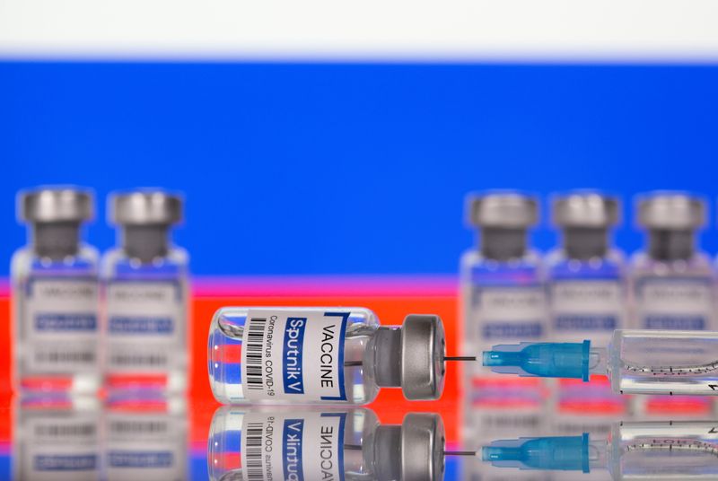 &copy; Reuters. Vials labelled "Sputnik V Coronavirus COVID-19 Vaccine" and a syringe are seen in front of a displayed Russian flag, in this illustration photo taken March 12, 2021. REUTERS/Dado Ruvic/Illustration