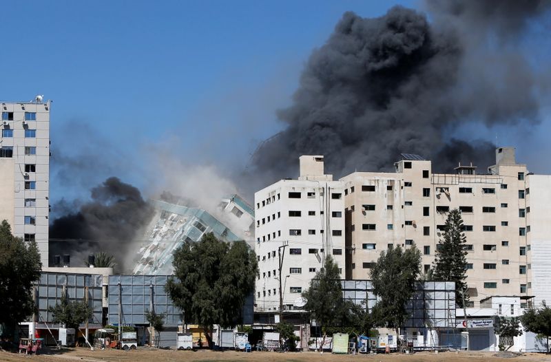 &copy; Reuters. البرج السكني الذي كان يضم مكتب وكالة أسوشيتد برس للأنباء في قطاع غزة ينهار بعد تعرضه لضربات جوية إسرائيلية يوم 15 مايو ايار 2021. تصوير: محمد سا