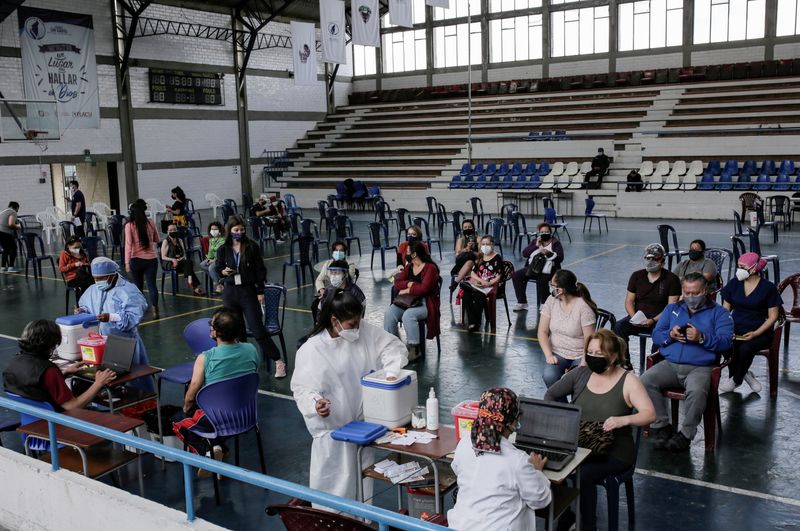 &copy; Reuters. FILE PHOTO: People wait to be vaccinated against the coronavirus disease (COVID-19) at the gymnasium of a school turned vaccination centre as Ecuador's government launched a plan to vaccinate nine million people in 100 days, in Quito, Ecuador June 1, 2021