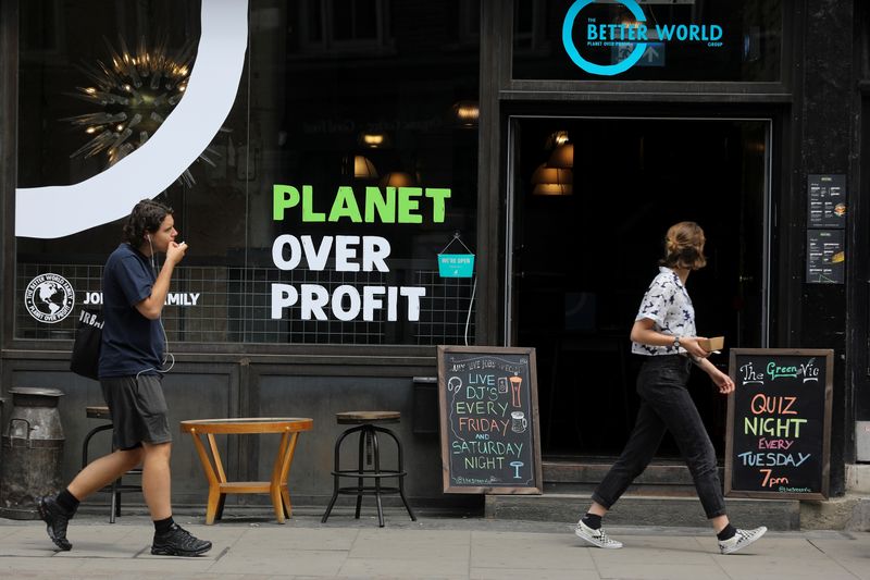 &copy; Reuters. FILE PHOTO: Pedestrians walk past the Green Vic, which is aiming to be the world's most ethical pub, in Shoreditch, London, Britain July 5, 2019. REUTERS/Simon Dawson