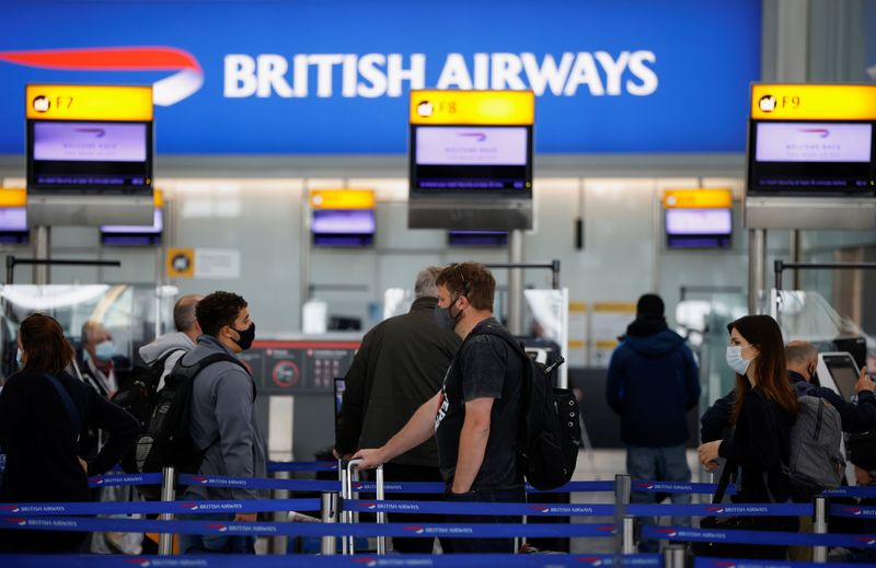 &copy; Reuters. FILE PHOTO:  Passengers stand in a queue to the British Airways check-in desks in the departures area of Terminal 5 at Heathrow Airport in London, Britain, May 17, 2021. REUTERS/John Sibley/File photo