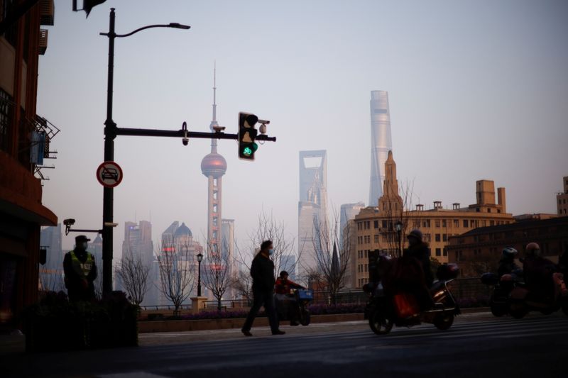 &copy; Reuters. People walk on a street, in front of Lujiazui financial district of Pudong, in Shanghai, China March 4, 2021. Picture taken March 4, 2021. REUTERS/Aly Song