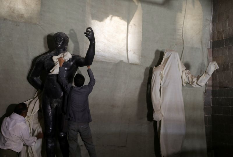 &copy; Reuters. موظفان ينظفان تمثالا في المتحف الوطني بصنعاء في الثاني من يونيو حزيران 2021. تصوير: خالد عبد الله - رويترز